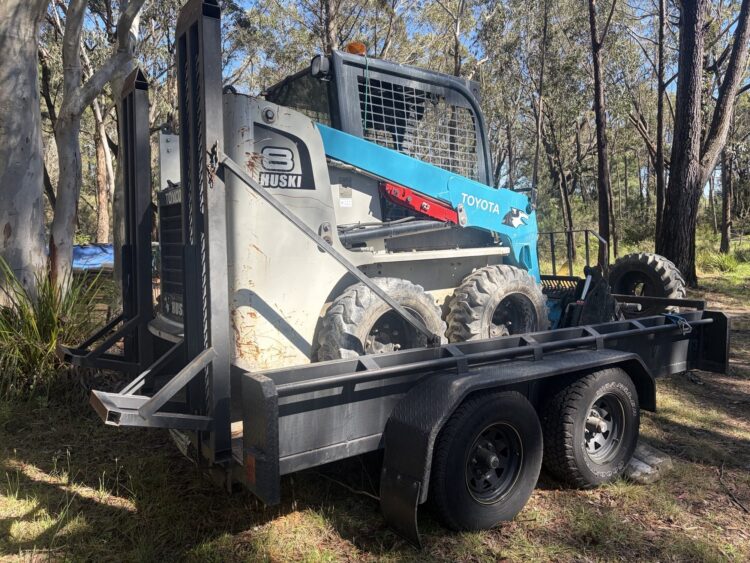 Toyota Huski 5SDK8 skid steer loader on its tandem trailer